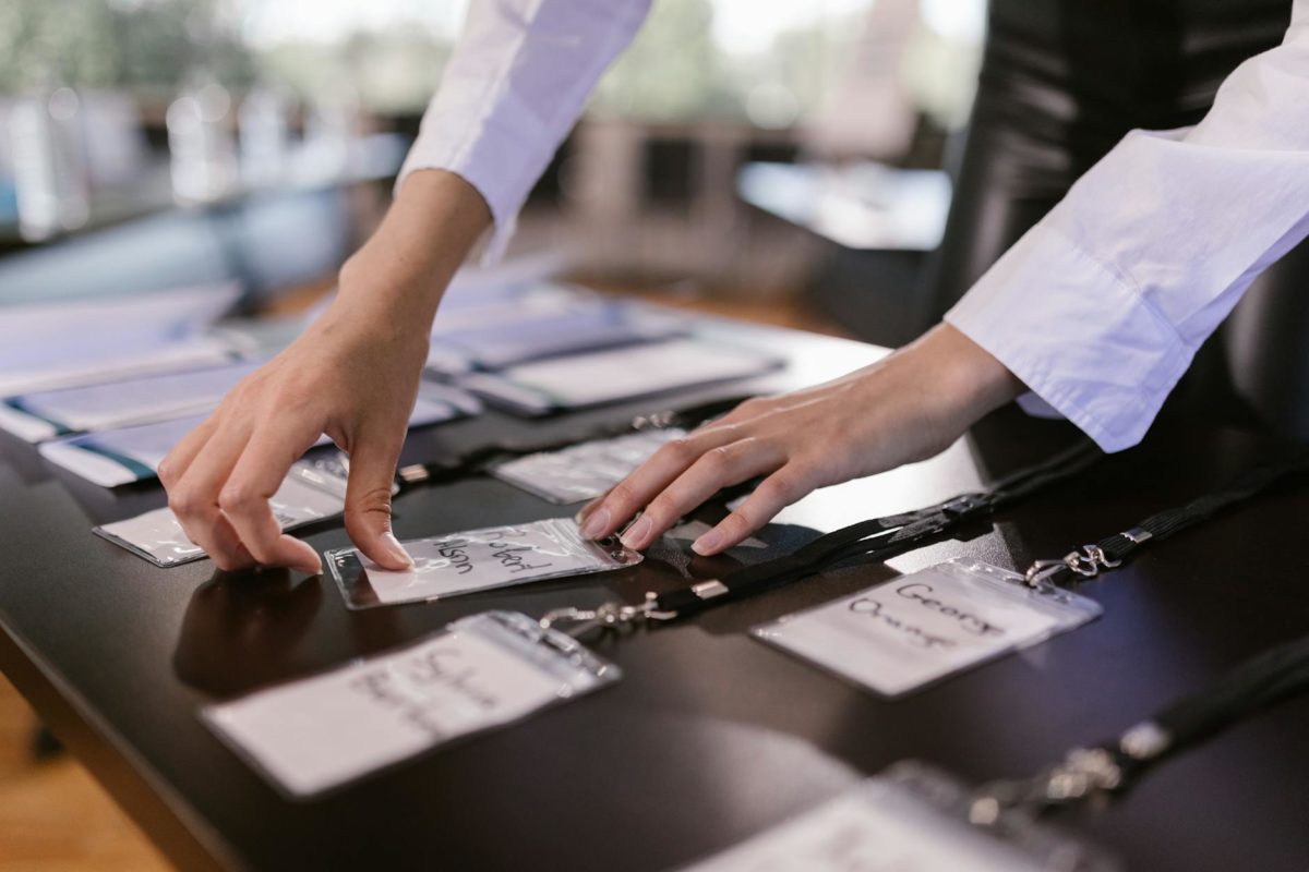person arranging name tags with laces on a desk